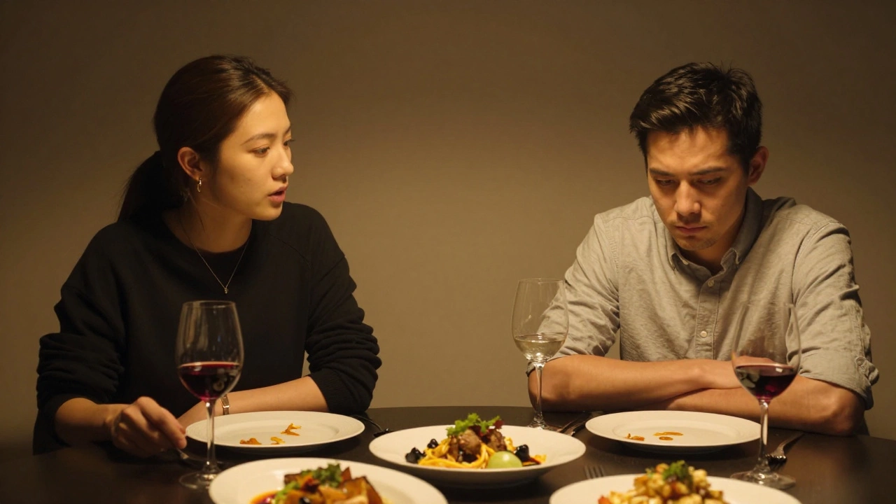 Two people at a dinner table, one silent and composed, the other speaking, emotional distance palpable.